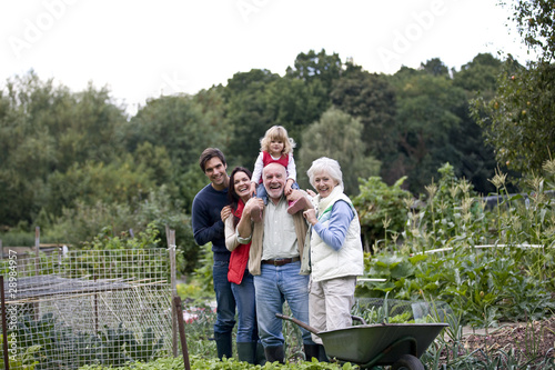 Foto: A family standing together on an allotment, laughing A family standing together on an allotment, laughing