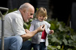 A grandfather showing a snail to his granddaughter