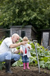 A grandfather showing a worm to his granddaughter
