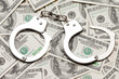 Photo: Handcuffs on dollar currency Handcuffs on dollar currency