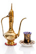 Arabic brass coffee pot with a welcoming a cup full of coffee.