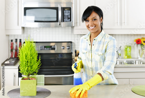 Photo: Young woman cleaning kitchen Young woman cleaning kitchen