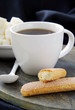 A cup of black coffee and refined sugar on a black background