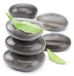 Spa stones with green leaves on a white background.