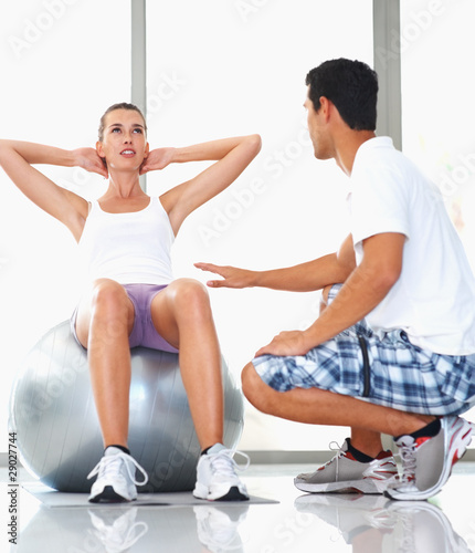 Photo: Woman exercising with personal trainer Woman exercising with personal trainer