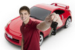 Attractive teenage boy holding car keys with car in the backgrou
