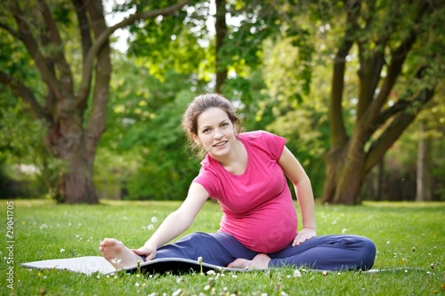 Photo: Beautiful pregnant woman practicing in the park Beautiful pregnant woman practicing in the park