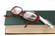Glasses on book and pen isolated in white Glasses on book and pen isolated in white