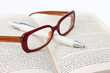 Glasses on book and pen isolated in white Glasses on book and pen isolated in white