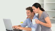 Couple looking at a video on the laptop