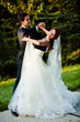 dancing wedding couple at a park on a sunny day