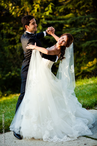 Photo: dancing wedding couple at a park on a sunny day dancing wedding couple at a park on a sunny day