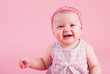 The small beautiful smiling girl on a pink background..