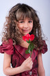 Beautiful little girl with red rose