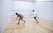 Squash players in action on a squash court (motion blurred image