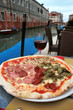 Venice: delicious pizza with a glass of wine,near the canal