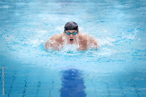 Foto: Swimmer in cap breathing performing the butterfly stroke Swimmer in cap breathing performing the butterfly stroke