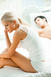 Portrait of unhappy young couple in bedroom