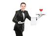 Waiter holding a silver tray with a glass of wine on it