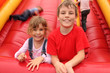 little boy and girl lying on red inflatable slide