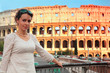 woman in white wear standing on bridge near Colosseum