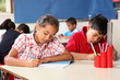 Boy and girl in classroom concentrating on lesson