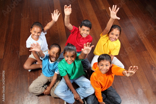 Photo: Six school children sitting in classroom hands up Six school children sitting in classroom hands up
