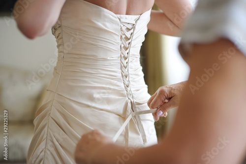 Photo: Helping the bride to put her wedding dress on Helping the bride to put her wedding dress on