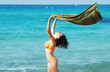 Beautiful young woman on the beach with a colored tissue Beautiful young woman on the beach with a colored tissue