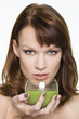 Young woman holding glass of wheatgrass juice