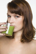 Young woman drinking glass of wheatgrass juice