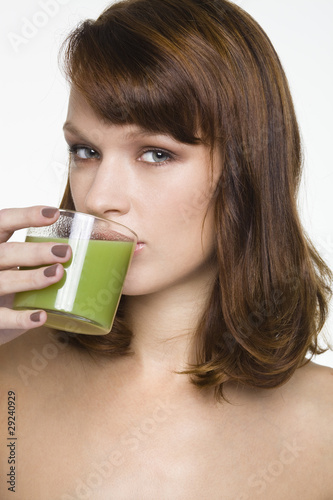 Photo: Young woman drinking glass of wheatgrass juice Young woman drinking glass of wheatgrass juice