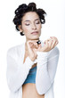 Young woman with hair clips, painting fingernails