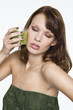 Young woman holding glass of wheatgrass juice