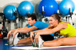 Paar im Fitnessstudio beim Dehnen