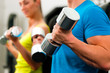 Paar mit Hanteln im Fitnessstudio
