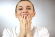 Portrait of a surprised young woman, grey background