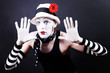 Funny mime in white hat with red flower