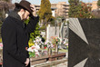 Mourning Man Standing on a Grave at the Cemetery