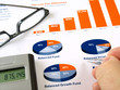 Male hand with pen on the investment chart with calculator Male hand with pen on the investment chart with calculator