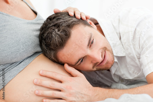 Foto: Husband listening to his wife's belly Husband listening to his wife's belly
