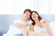 Photo: Smiling couple watching tv at home Smiling couple watching tv at home