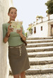 Tourist standing on steps reading map in Granada, Spain, front view