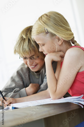 Photo: Brother and Sister Doing Homework at table in home Brother and Sister Doing Homework at table in home