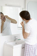 Photo: Man flossing teeth in mirror in bathroom Man flossing teeth in mirror in bathroom