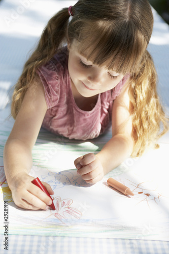 Photo: Young girl lying on table in back yard drawing Young girl lying on table in back yard drawing