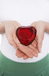 Woman showing heart-shaped jewel, mid section