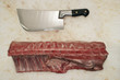 Photo: Cleaver and Raw Meat on Countertop, view from above Cleaver and Raw Meat on Countertop, view from above