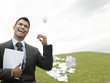Laughing business man on grass field throwing litter behind