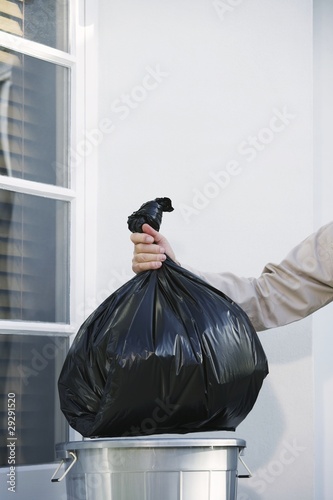 Photo: Man Taking Garbage Out of Can Man Taking Garbage Out of Can